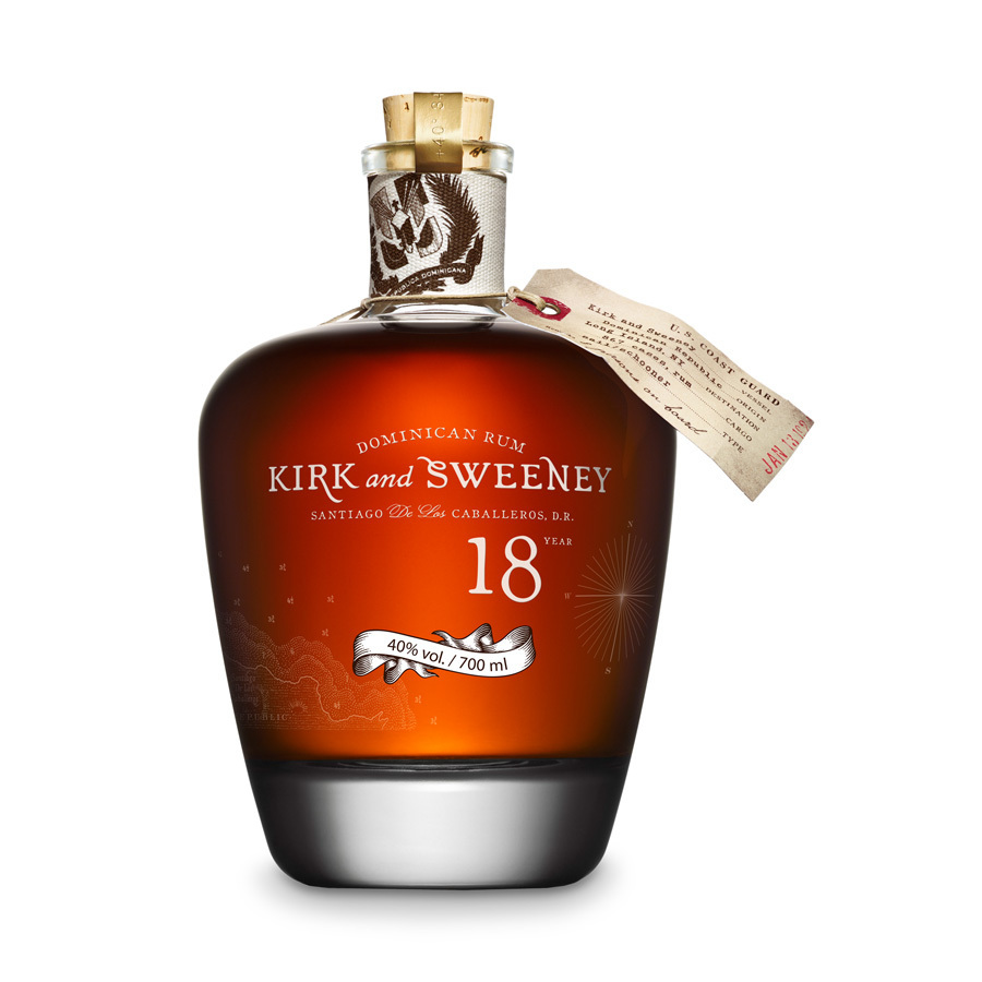Kirk & Sweeney Gran Reserva Rum bottle with a dark amber liquid, elegant round shape, decorative label, and a cork stopper, featuring a tag and intricate design elements.