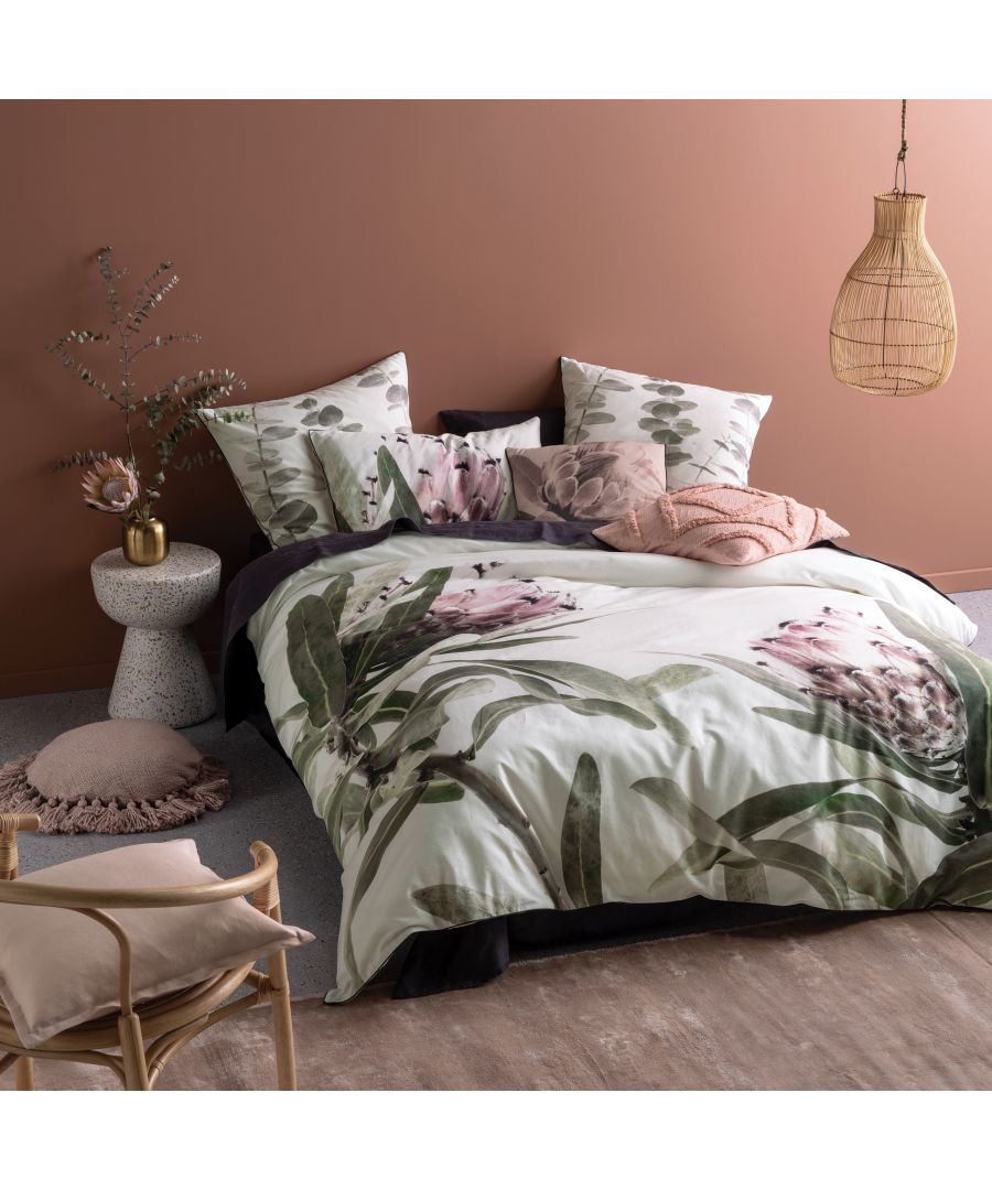 Purple cotton duvet set featuring floral designs, complemented by matching pillows, styled on a bed with a neutral backdrop and decorative elements like a woven pendant light and side table.