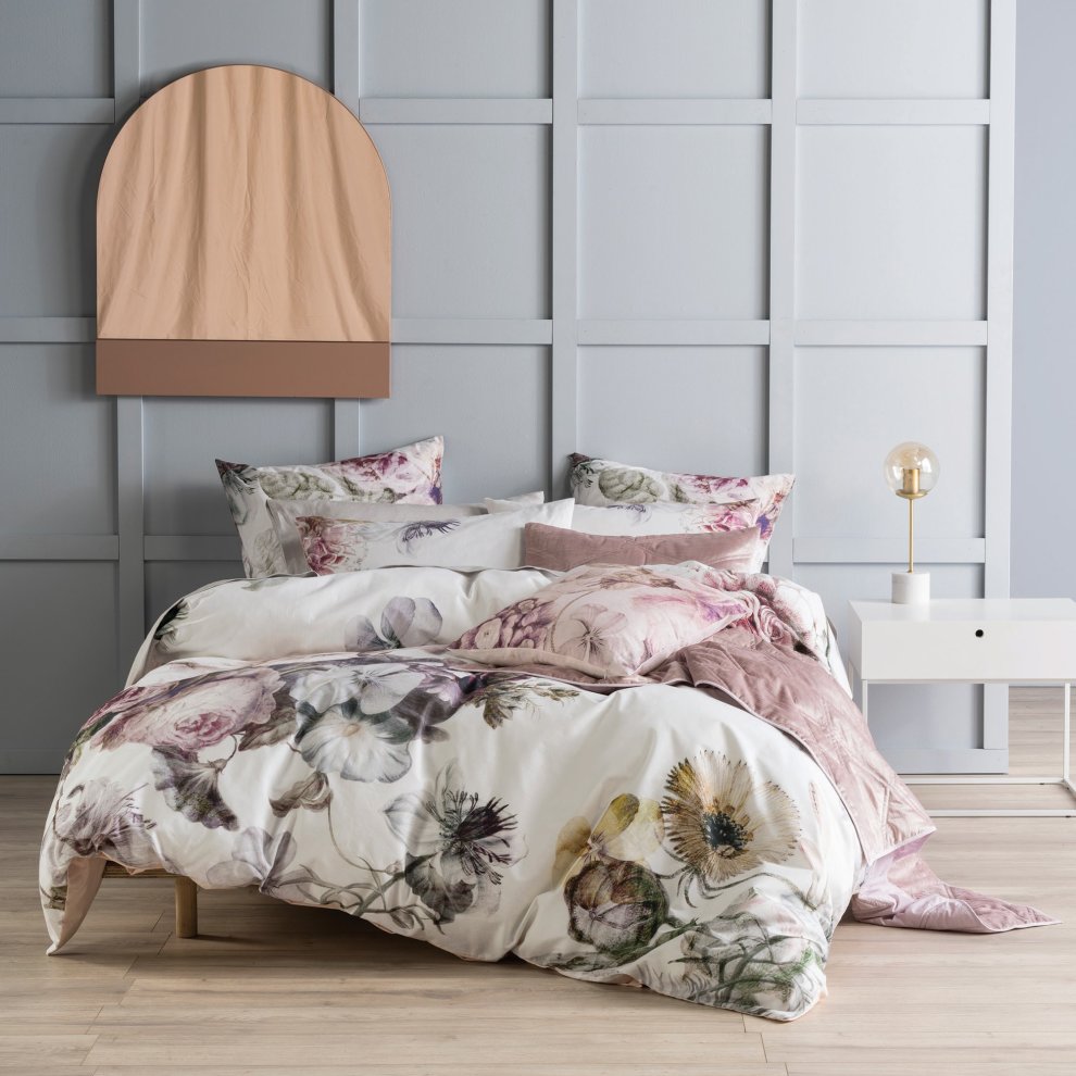 Linen House Ellaria Duvet Set in pink features a floral design on soft fabric, complemented by matching pillowcases, styled on a bed against a light grey wall with a modern decor.