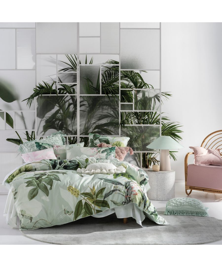 Multicolour cotton duvet cover set featuring tropical leaf patterns, complemented by soft pastel pillows, set against a modern, plant-filled backdrop.