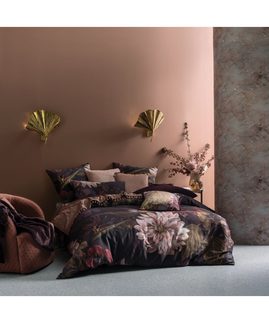 Multicolour cotton duvet cover set featuring floral designs, complemented by coordinating cushions, against a warm-toned wall and elegant gold wall sconces.
