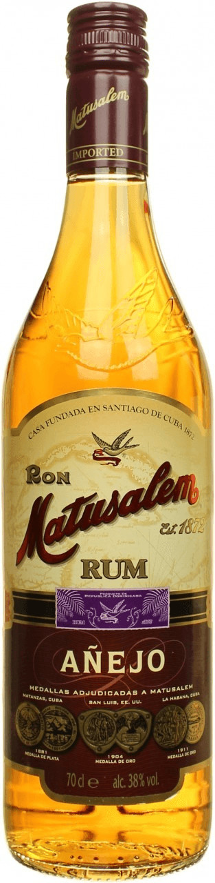 Clear glass bottle of Matusalem Anejo Rum, 70 Cl, featuring a golden amber liquid, a cream label with gold accents, and a vintage-style design.