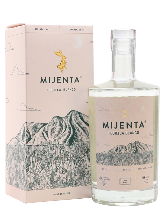 Clear glass bottle of Mijenta Blanco Tequila with a cork stopper, featuring a minimalist design and a light greenish liquid, alongside a pastel pink box adorned with mountain illustrations.
