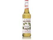 Clear plastic bottle of Monin Hazelnut Sugar Free Syrup, 1 L, featuring a white label with green and brown accents, and a red and white striped cap.
