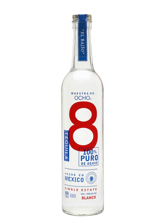 Clear glass bottle with a tall, slender shape, featuring a blue and red label that reads "Muestra No. 8 Tequila," "100% Puro de Agave," and "Hecho en Mexico."