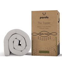 White bamboo mattress topper rolled up beside its eco-friendly packaging, featuring a brown box with green accents and the Panda logo prominently displayed.