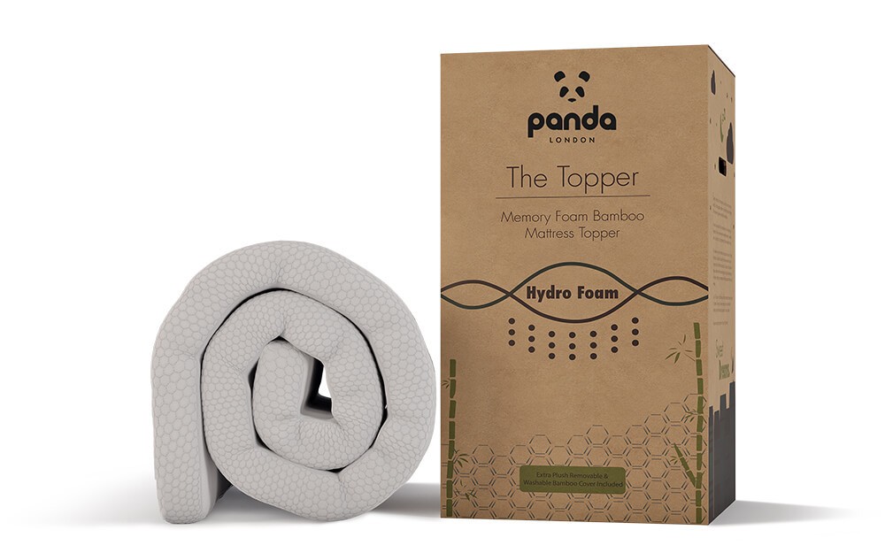 Rolled white memory foam mattress topper with a textured surface, packaged in a brown cardboard box labeled "Panda" and featuring bamboo and hydro foam details.