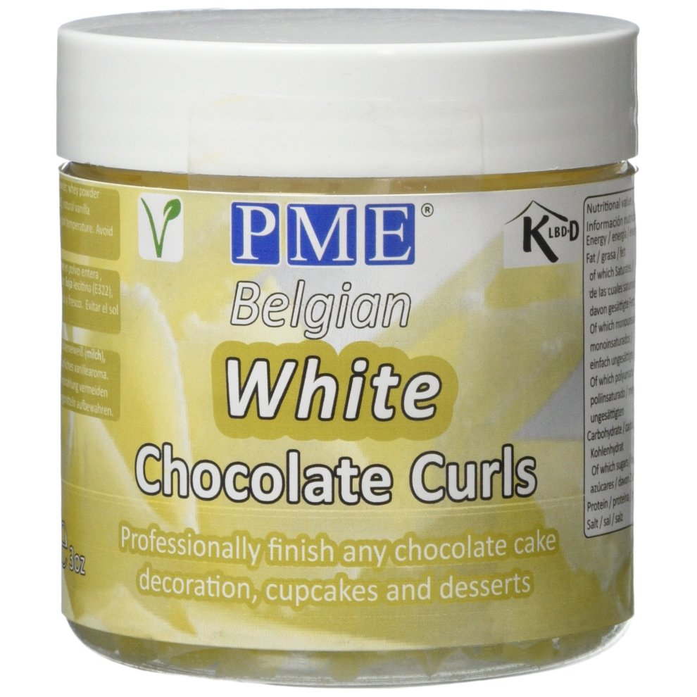 White chocolate curls in a clear plastic container with a yellow label, featuring "PME Belgian White Chocolate Curls" text and usage suggestions for cake decoration.