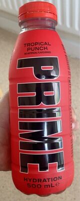 Bright red bottle of Prime Tropical Punch hydration drink, featuring bold black lettering, with a 500 mL capacity, held in a hand against a light background.