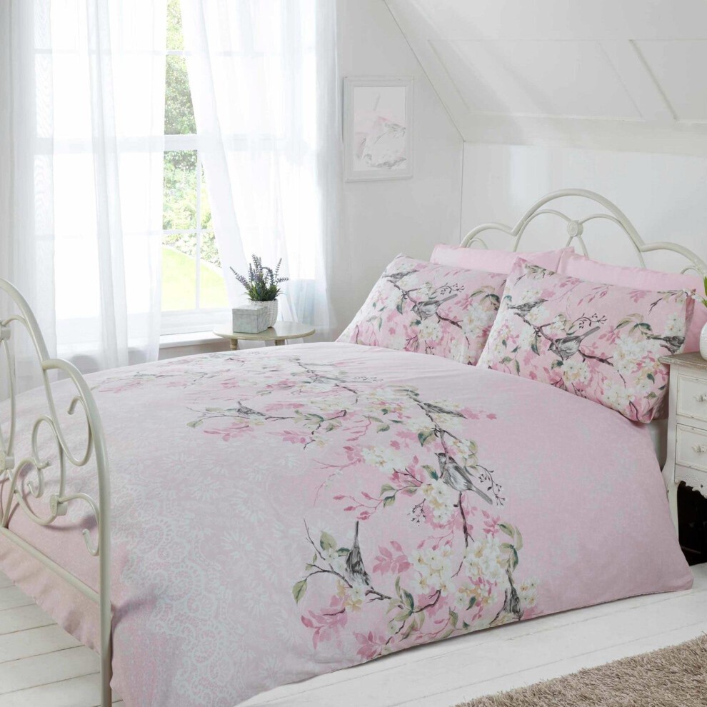 Pink super king duvet cover featuring a delicate floral design with blossoms, complemented by matching pillowcases, set in a bright, airy bedroom with natural light.