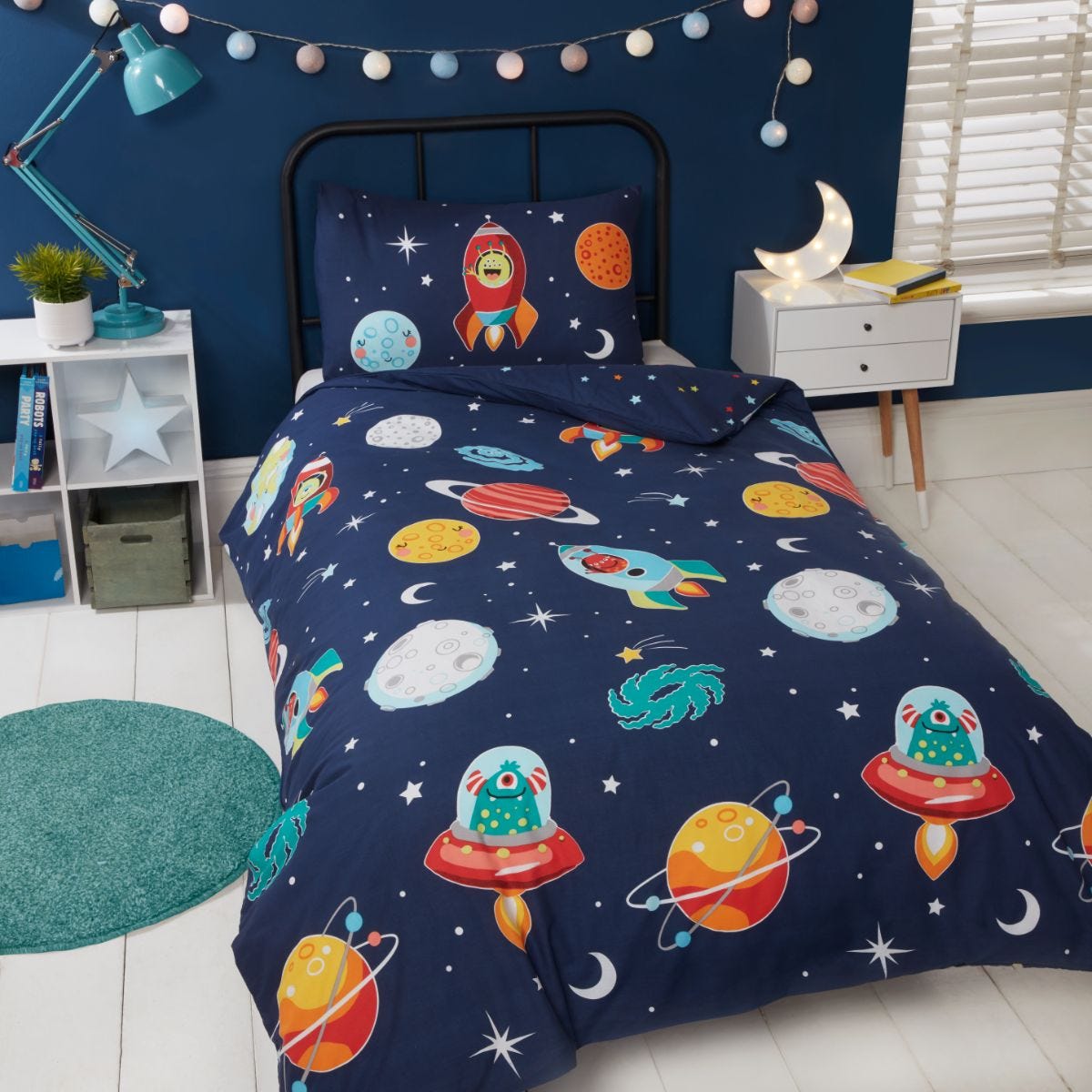 Colorful toddler duvet set featuring playful aliens, rockets, and planets on a dark blue background, complemented by a matching pillowcase and a cozy, soft fabric.