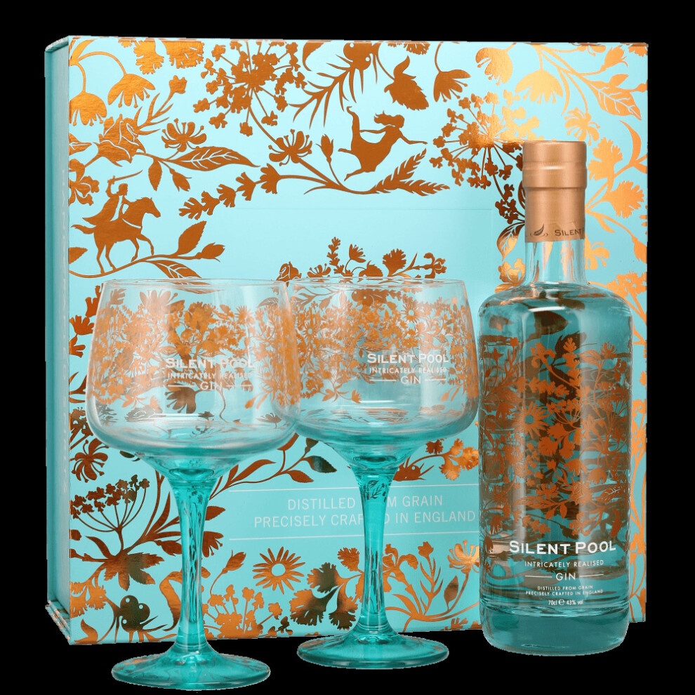 Elegant gift set featuring a 70 Cl bottle of Silent Pool Gin in a clear glass, accompanied by two ornate turquoise stemmed glasses, all presented in a beautifully designed blue and gold box.