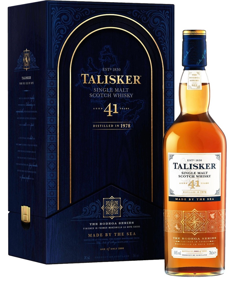 Talisker 1978 Bodega Series 41 Year Old Whisky in a clear glass bottle with a golden label, housed in a dark blue box featuring intricate gold designs.