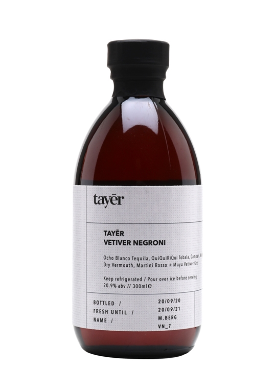 A dark amber bottle with a black cap, featuring a white label that reads "TAYĒR VETIVER NEGRONI" and details about the contents, including alcohol percentage and bottling date.