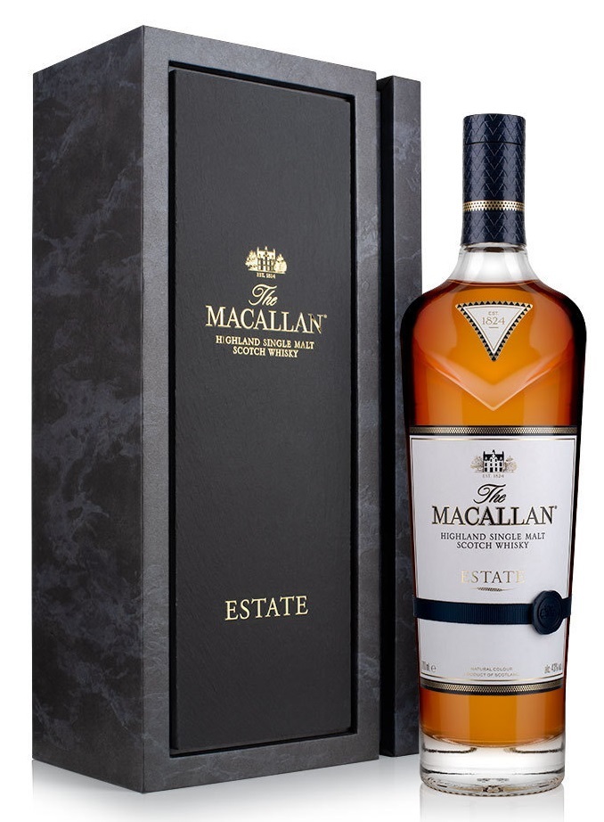 Amber-colored bottle of The Macallan Estate Highland single malt Scotch whisky, presented in a sleek black box with gold lettering and a blue label, showcasing elegance and luxury.