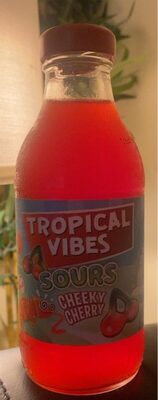 Bright red bottle of Tropical Vibes Cheeky Cherry drink, featuring a playful label with cherries and the text "Tropical Vibes Sours," set against a blurred green background.