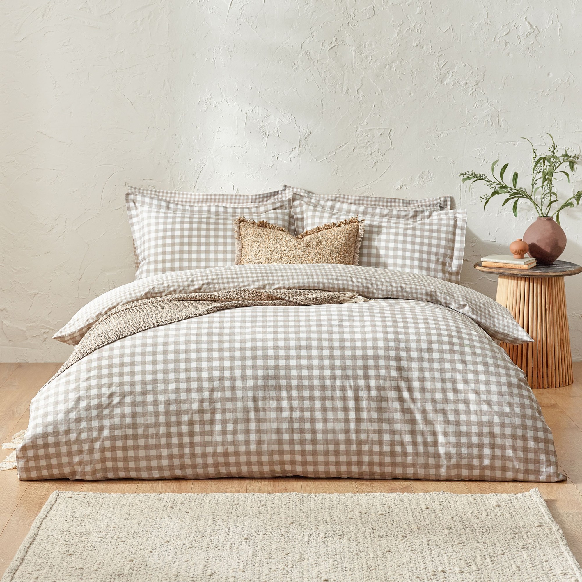 Natural-colored super king duvet cover set in 100% cotton featuring a classic check pattern, complemented by matching pillowcases and a textured decorative cushion.