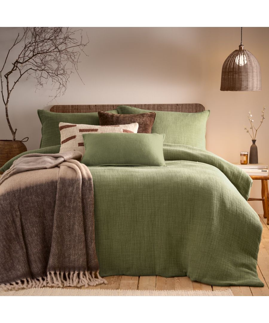Khaki cotton duvet cover set in king size features an acid-washed texture, complemented by decorative pillows and a soft throw blanket on a wooden bed frame.