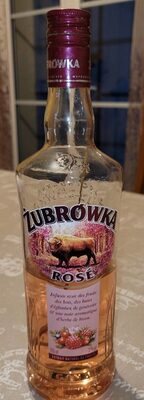 Zubrowka Rose Liqueur bottle, 70 cl, features a pink liquid, a decorative label with a bison, and a purple cap, set against a softly lit background.