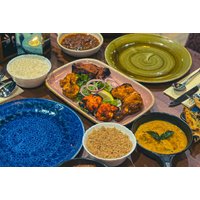 Assorted Indian street food dishes on colorful plates, including grilled meats, rice, and curry, set on a dining table.