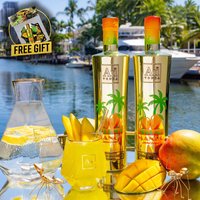 Au Vodka Miami Mango 70cl bottle with tropical palm design, vibrant yellow-orange gradient cap, set by a marina.