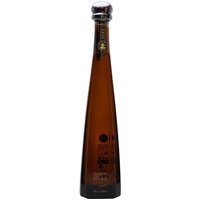Tall, slender brown glass bottle of Don Julio 1942 Tequila Magnum with gold lettering and a black cap.