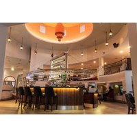 Hotel lobby with modern circular bar, warm lighting, high ceilings, and elegant seating in Waterfoot Hotel.