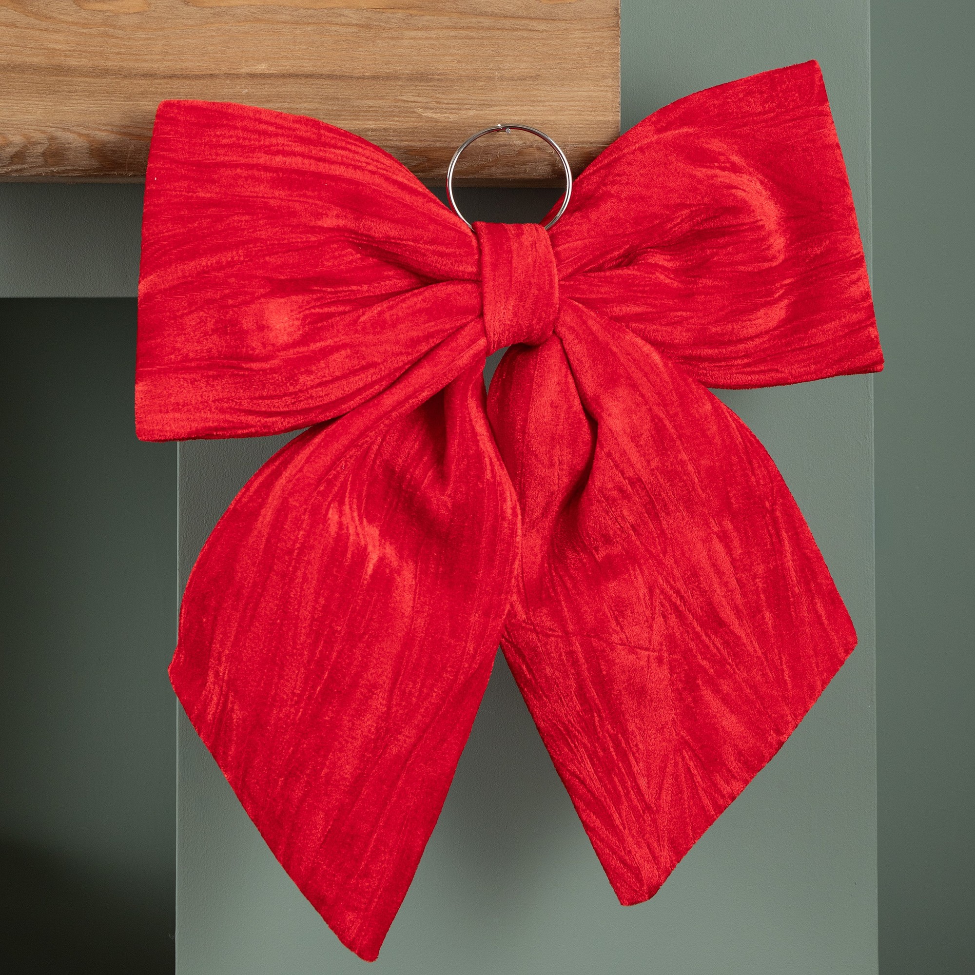 Luxurious 44cm red velvet Christmas bow decoration with a textured finish, featuring a large, elegant design and a metal ring for hanging.