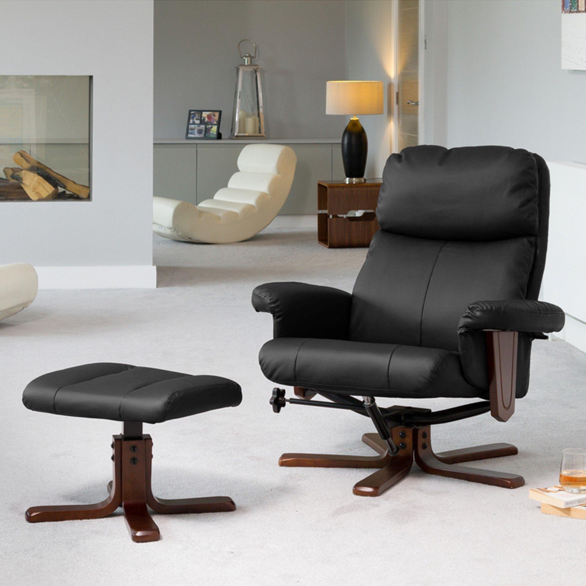 Black leather swivel recliner with matching ottoman, featuring a wooden base, massage and heat functions, set in a modern living room with neutral decor.