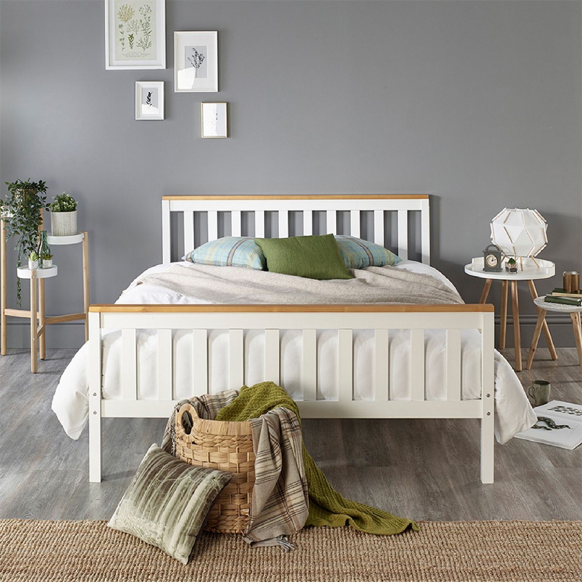 White Atlantic bed frame with natural wood tops, featuring a slatted headboard and footboard, complemented by a cozy bedding set and decorative plants in a modern room.