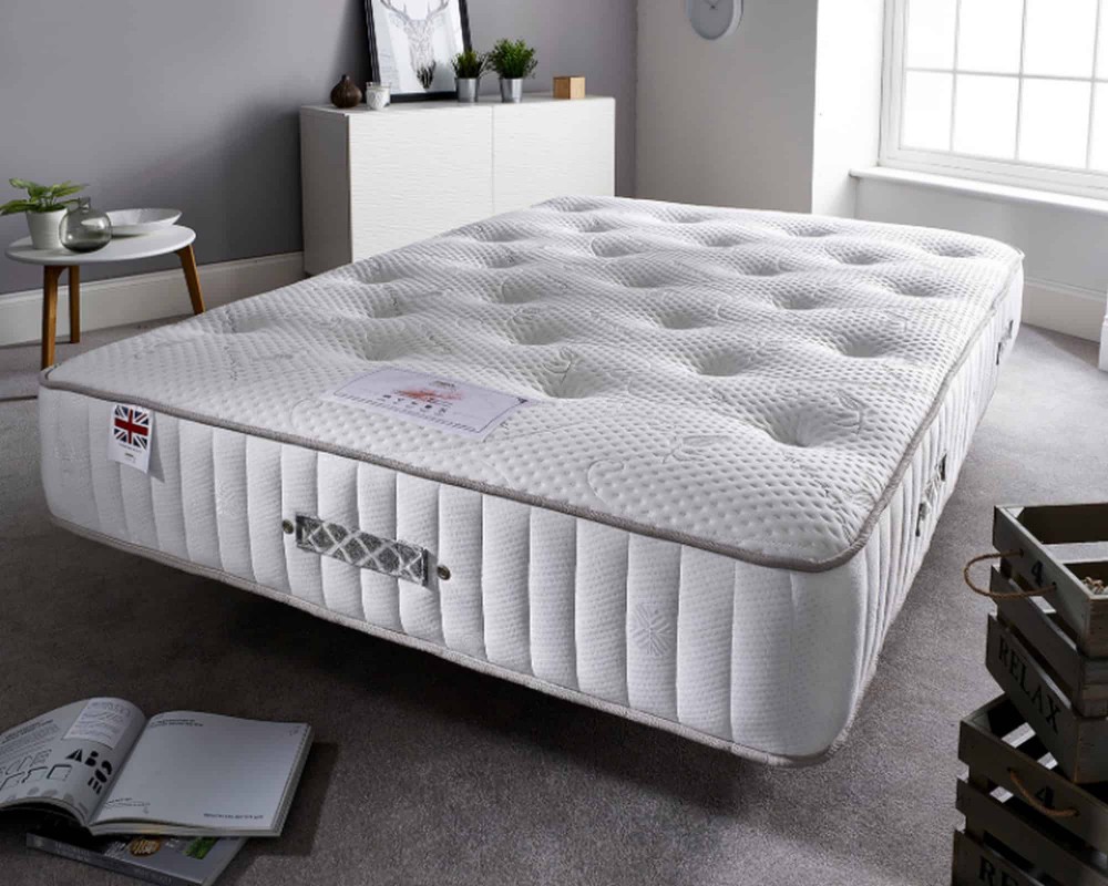 Aspire Natural Cashmere 1000 Pocket Mattress in white, featuring a quilted surface, small single size, and a label with the Union Jack, positioned on a soft carpet.