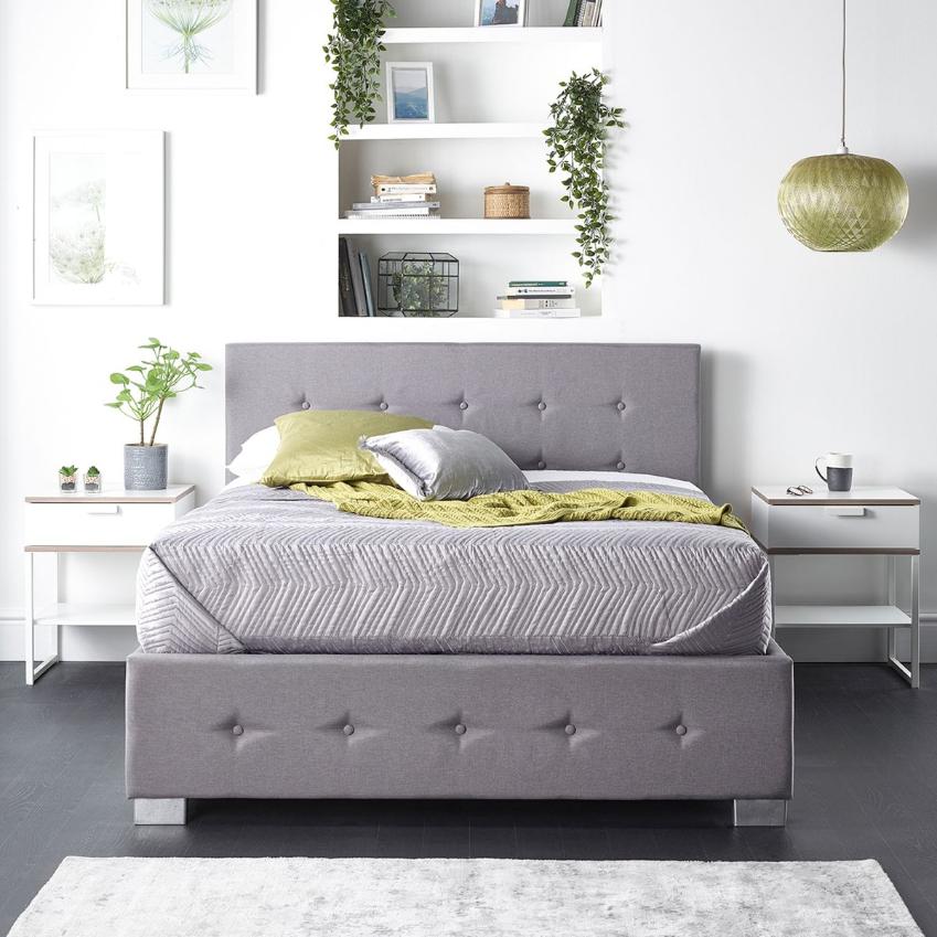 Grey linen super king ottoman storage bed with a side opening, featuring a button-tufted headboard and sleek chrome legs, complemented by a cozy bedding arrangement.