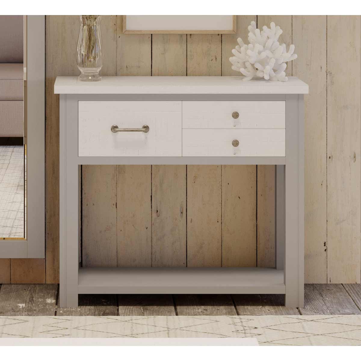 Grey hall table featuring a sleek design with a white top, two drawers with silver handles, and a sturdy base, set against a rustic wooden backdrop.