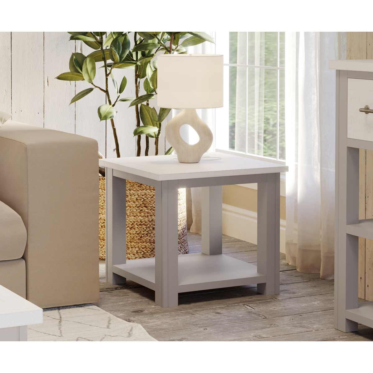 Grey wooden lamp table with a lower shelf, featuring a light-colored ceramic lamp with an abstract design, set beside a beige sofa and a potted plant in a cozy interior.