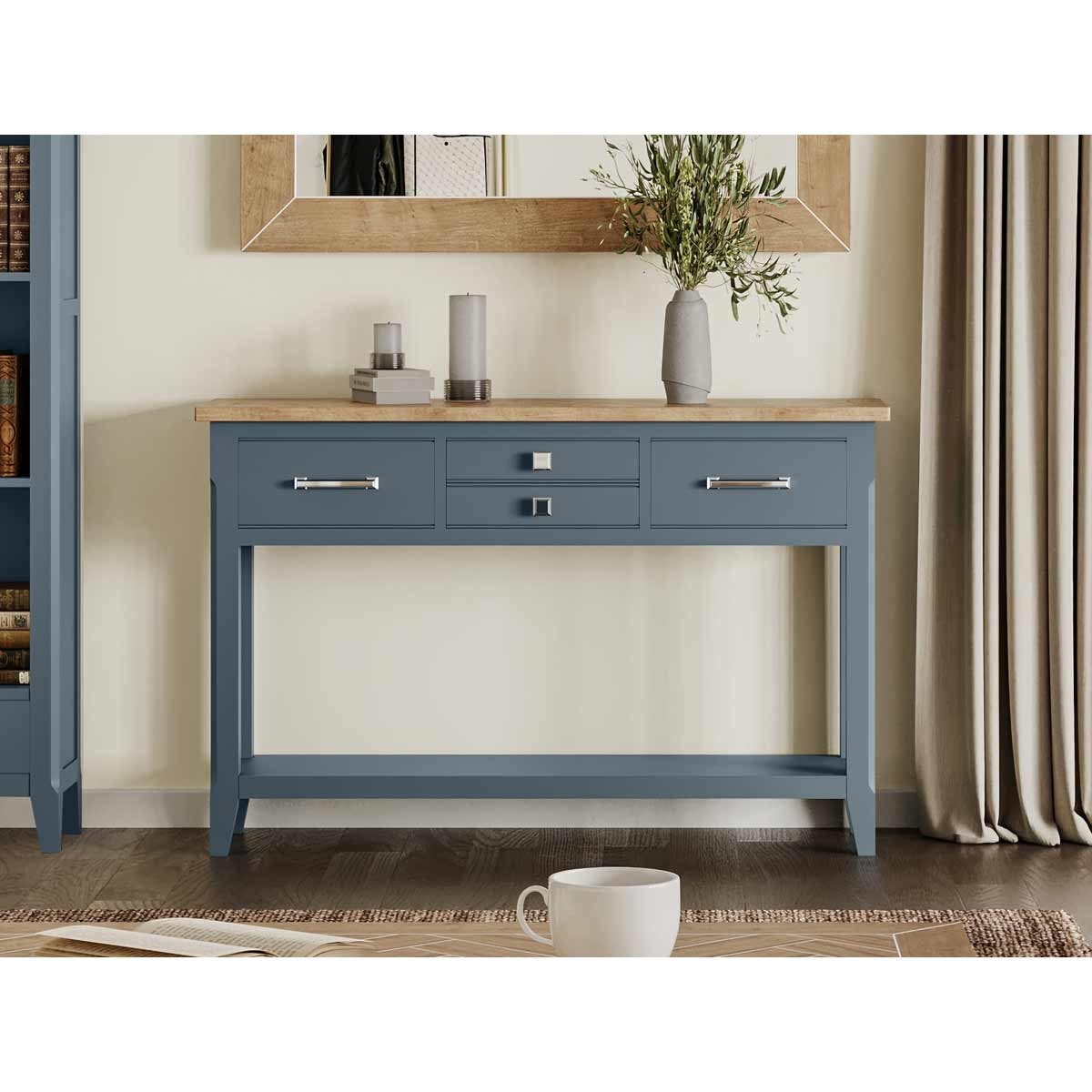 Cobalt blue console table with a natural wood top, featuring three drawers with sleek silver handles, set against a neutral wall and a decorative mirror.