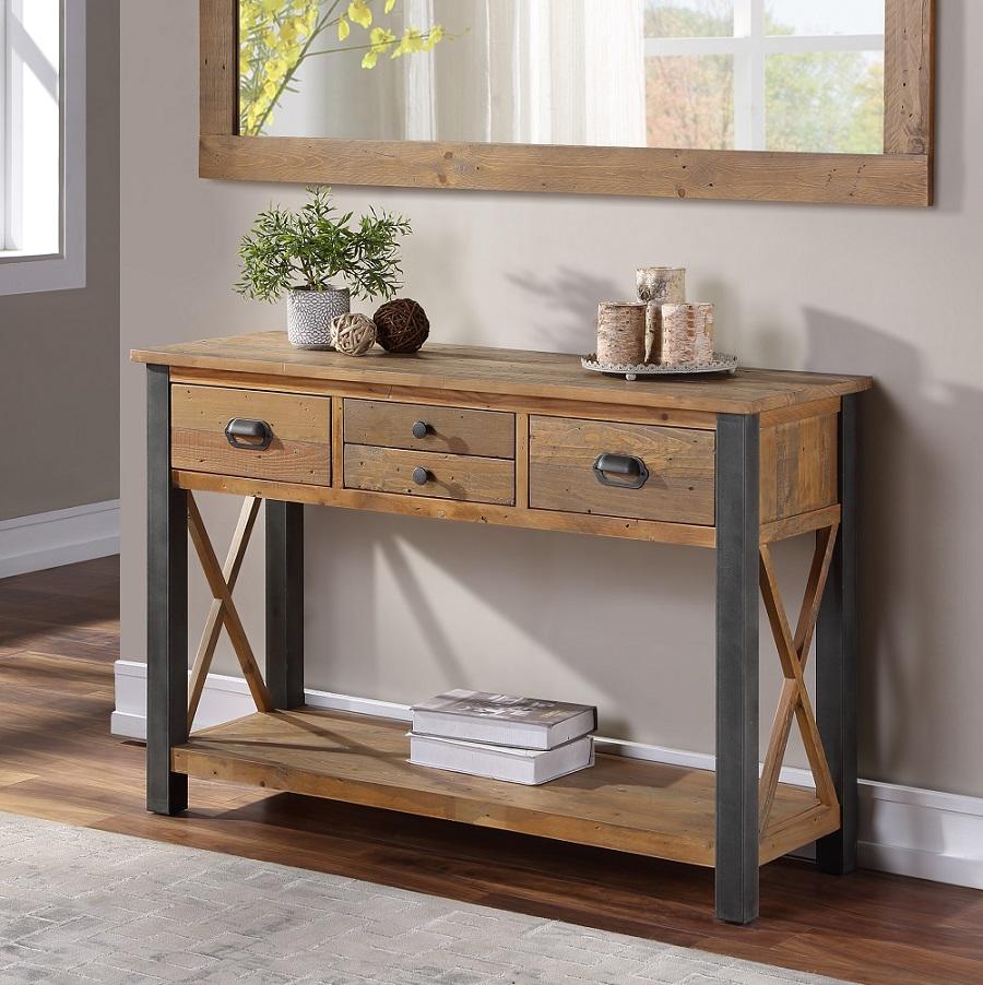 Reclaimed brown wood console table with three drawers, metal handles, and an open shelf, featuring an X-frame design and a rustic finish, set against a light wall.