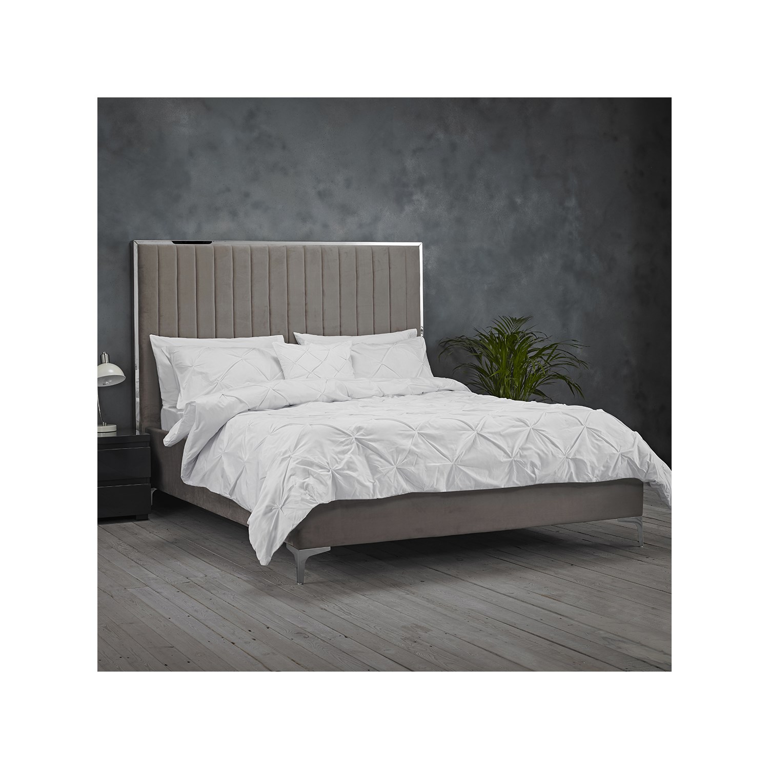 Grey upholstered Berkeley double bed by LPD Furniture featuring a tall, tufted headboard, sleek metal legs, and a minimalist design, complemented by white bedding and a dark wood nightstand.