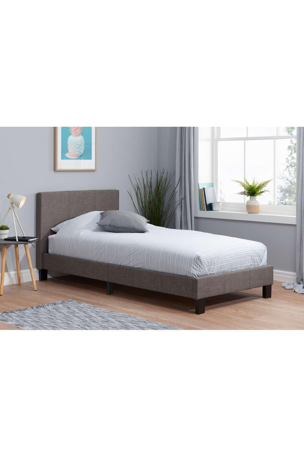 Single Birlea Berlin bed in grey fabric with a sleek headboard, paired with a striped mattress and a simple bedside table, set against a light, modern room backdrop.