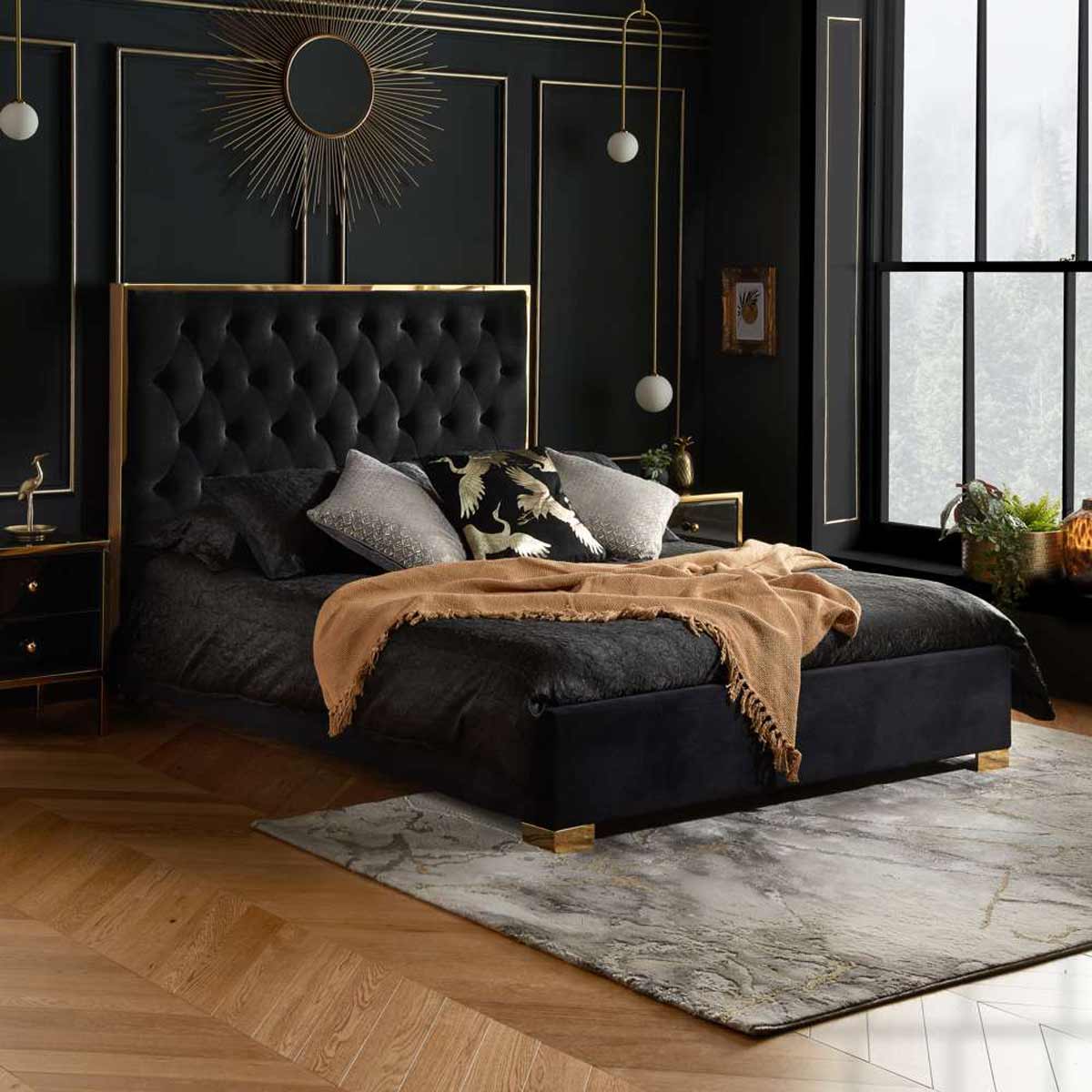 Black upholstered king bed frame featuring a tufted headboard, gold accents, and a stylish design, complemented by decorative pillows and a cozy throw blanket.