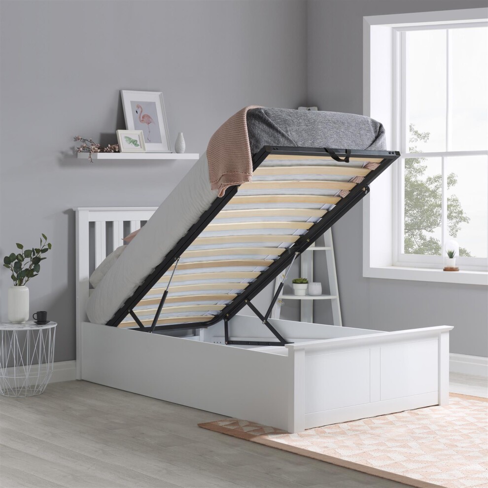 Single solid wood ottoman bed storage frame in white, featuring a lifted mattress revealing spacious storage beneath, with a light gray blanket draped over the top.