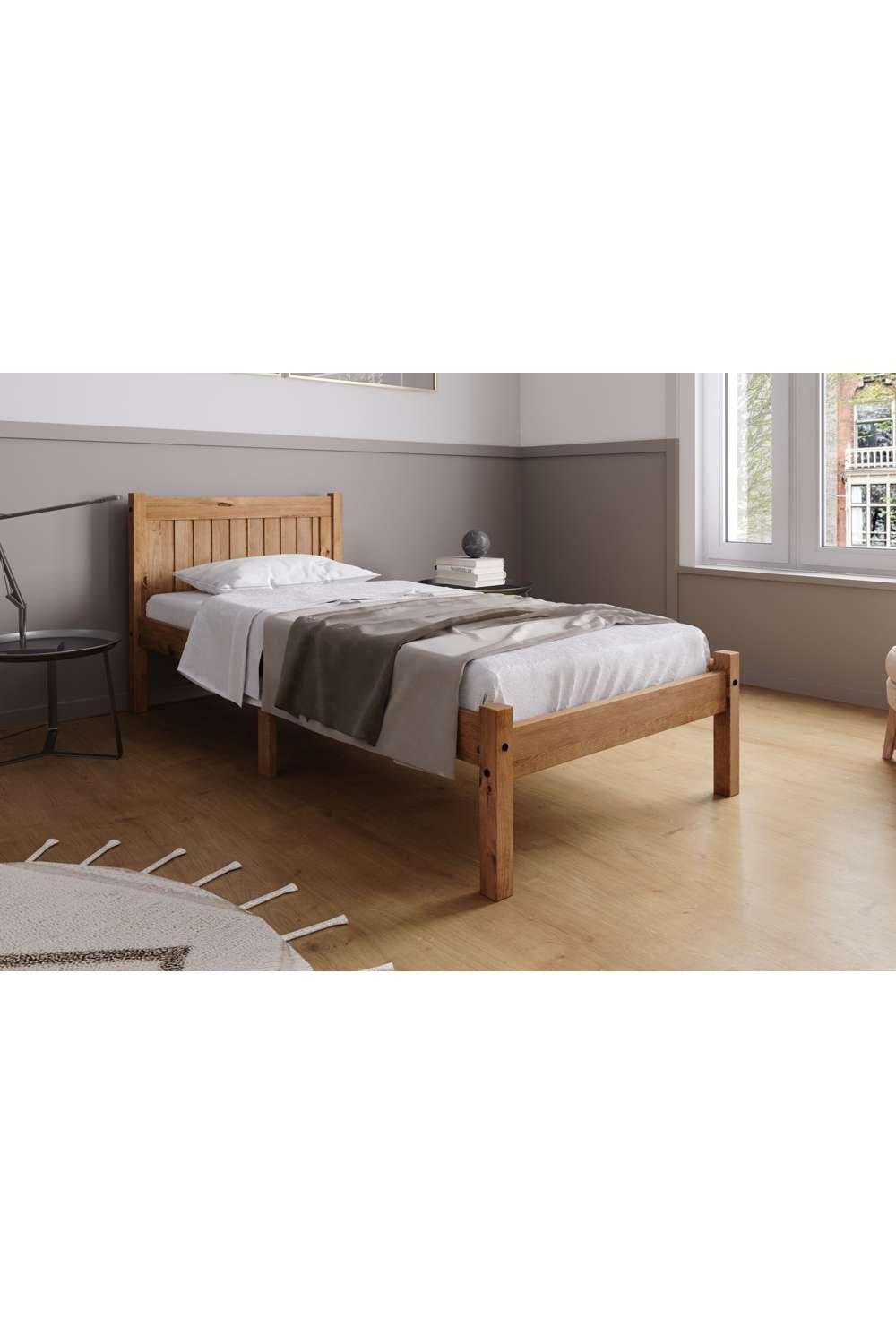 Single Trent Bed by Birlea in brown wood, featuring a slatted headboard, sturdy frame, and a minimalist design, set against a light-colored room with wooden flooring.