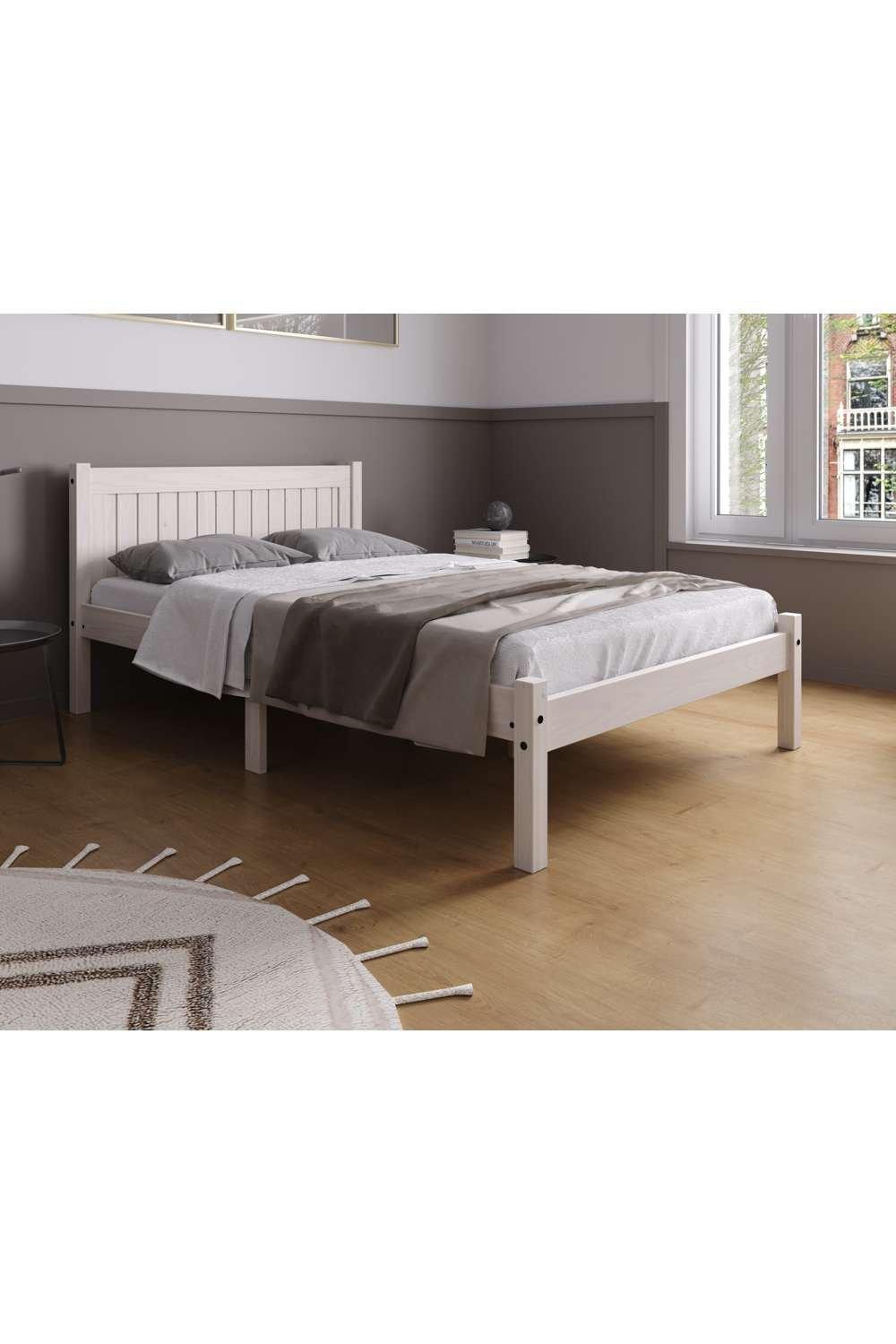 White wooden small double bed with a slatted headboard and sturdy legs, featuring a minimalist design and soft grey bedding, set on a light wooden floor.