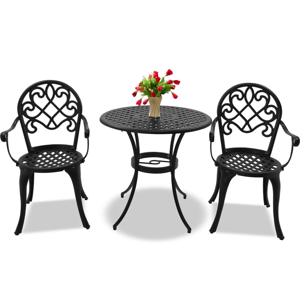 Black cast aluminum bistro set featuring a round table with a decorative lattice design and two large chairs with armrests, complemented by a vase of flowers.