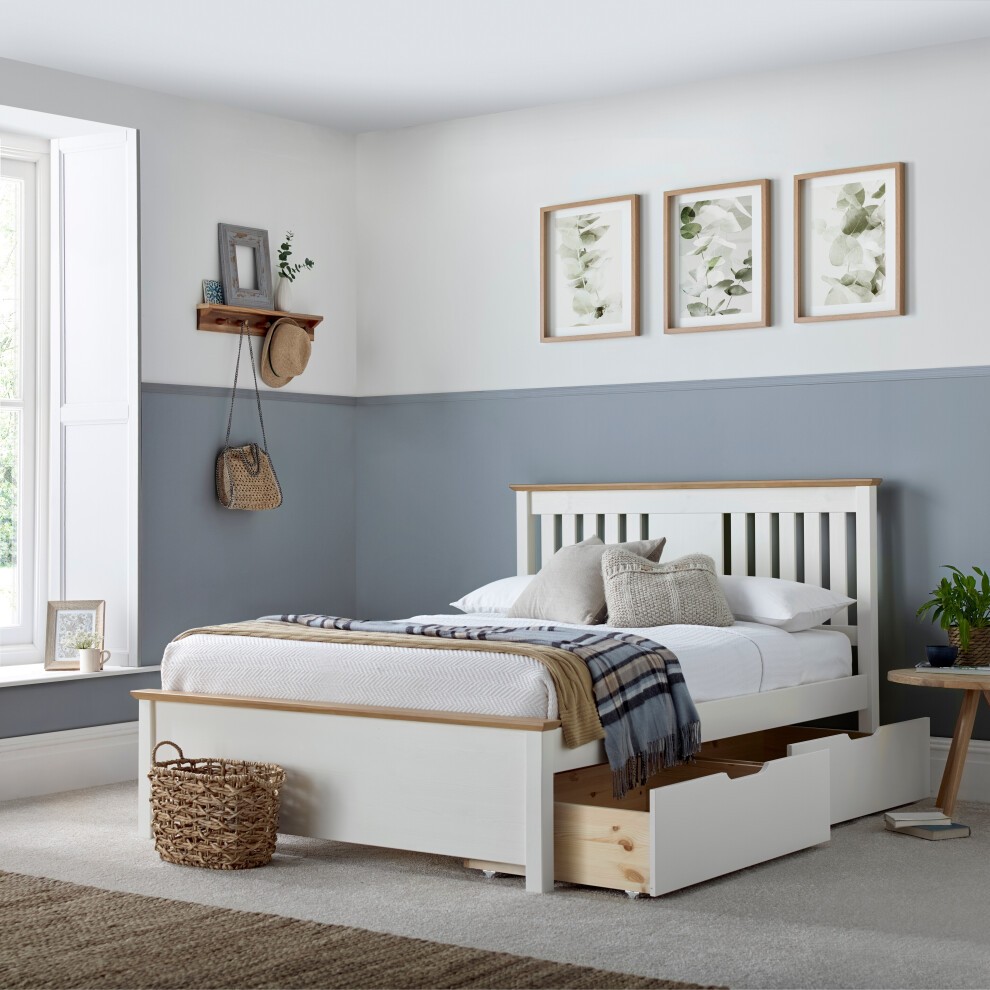 Cheshire white wooden storage bed with two drawers, featuring a slatted headboard, light wood accents, and a cozy bedding arrangement in a softly decorated room.