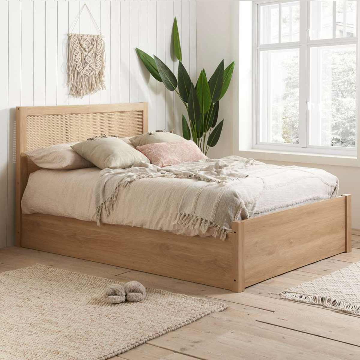 Rattan ottoman bed frame in brown oak finish, featuring a woven headboard, double size, with plush bedding and decorative pillows in a cozy, well-lit room.