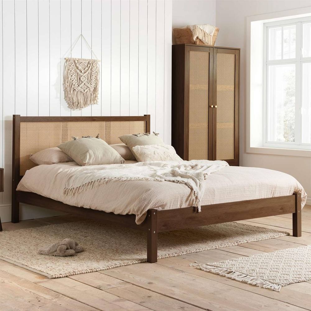 Brown rattan bed frame with a woven headboard, featuring a 4FT6 double size, complemented by neutral bedding and a light, airy room with wooden flooring.