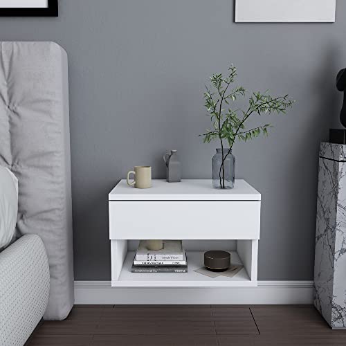 White floating wall-mounted nightstand with a drawer and open shelf, featuring a minimalist design, placed beside a bed, adorned with a vase and a cup.