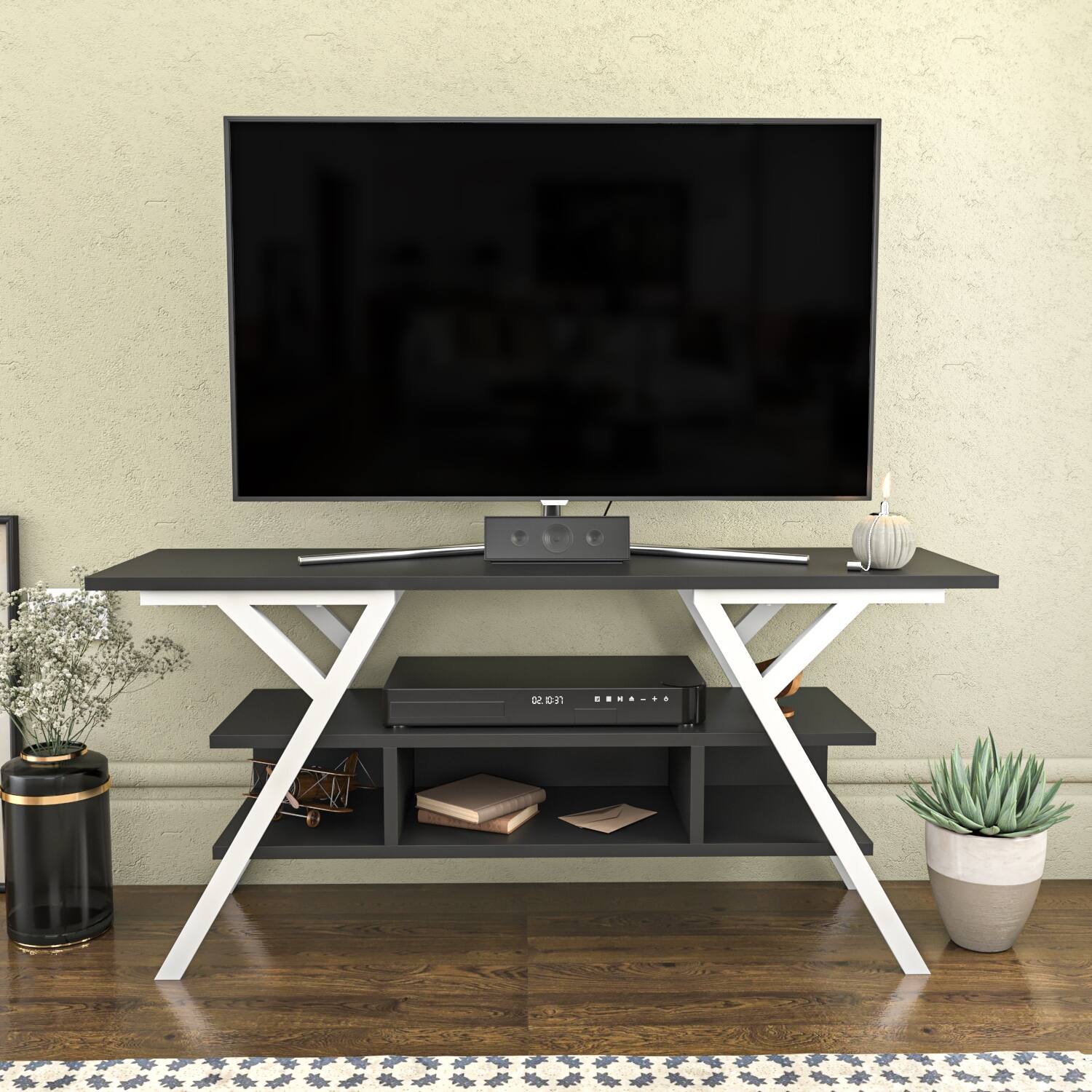 Wade Logan Airalyn TV stand in white wood, featuring a sleek design with a black top, open shelving, and an X-shaped base, suitable for TVs up to 50 inches.