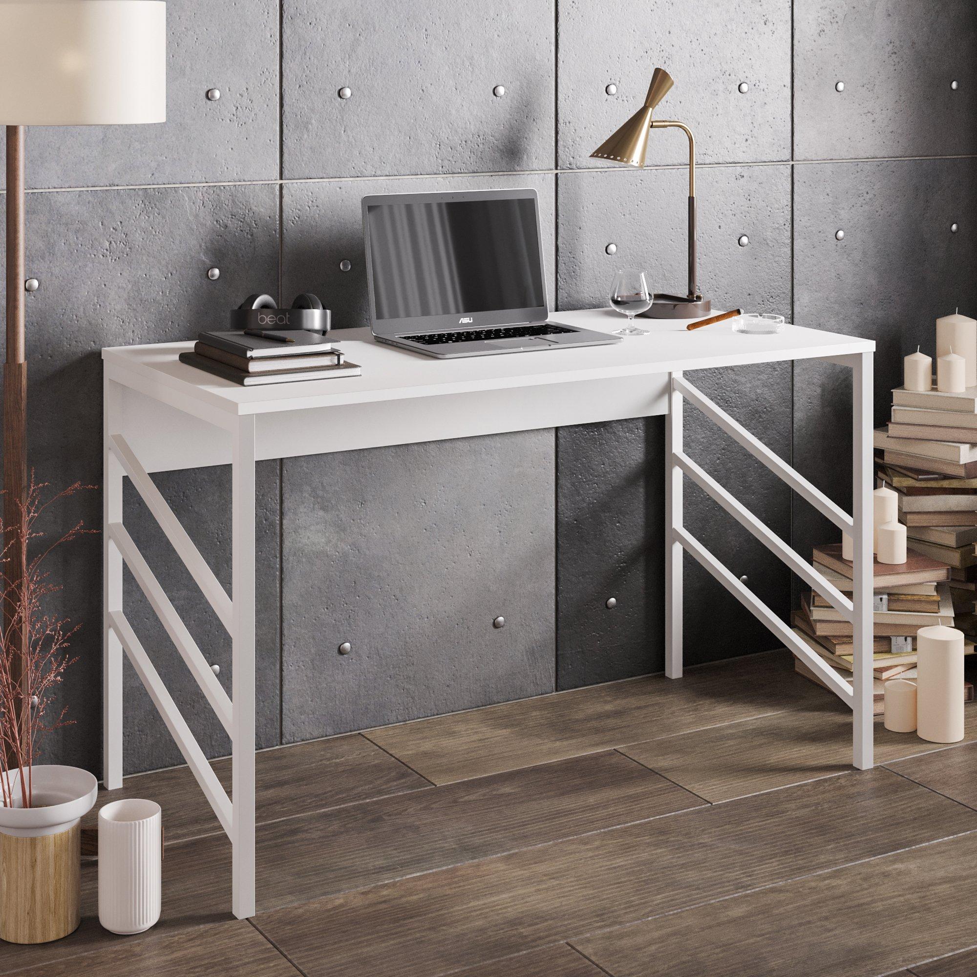 White metal writing desk with a sleek design, featuring a minimalist top, angular legs, a laptop on the surface, and decorative items like books and candles nearby.