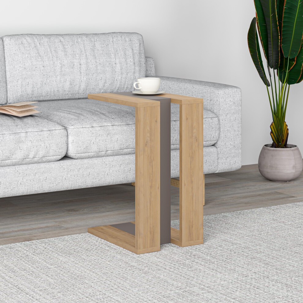 Mocha grey particleboard C-table with oak finish, featuring a sleek design and open base, positioned beside a light grey sofa with a cup on top.